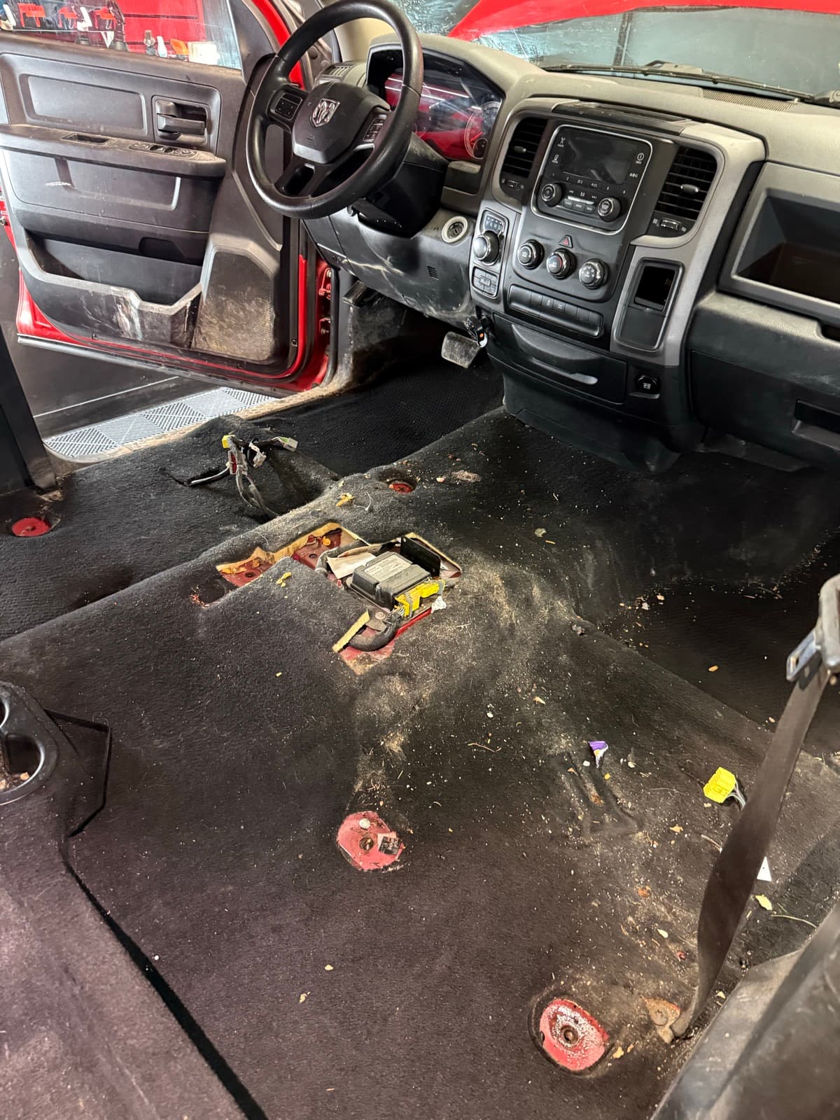 Bare truck carpet with embedded dirt and debris exposed during a deep interior clean
