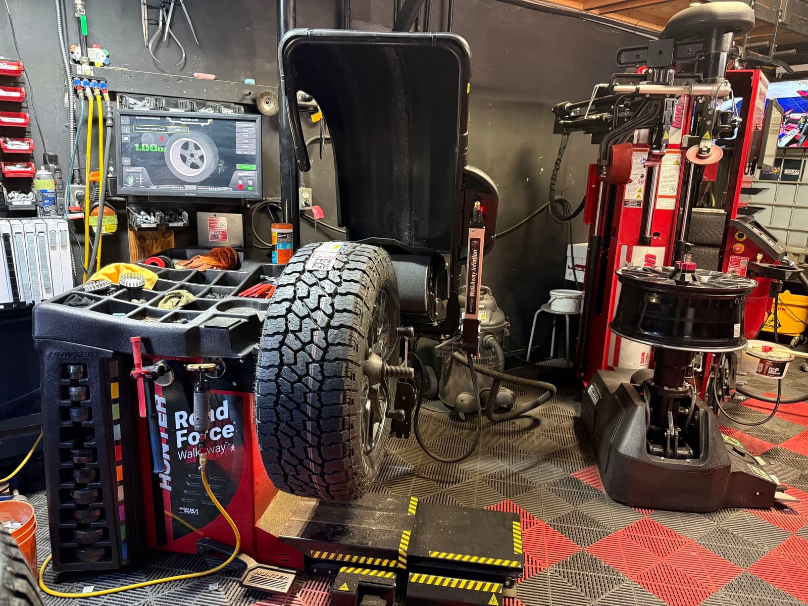 All-terrain truck wheel on the Hunter balancer next to the Hunter Revolution tire changer