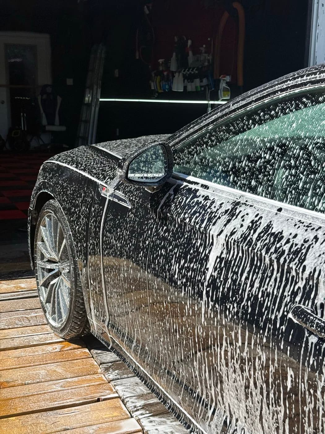 Sedan covered in thick foam during an exterior wash