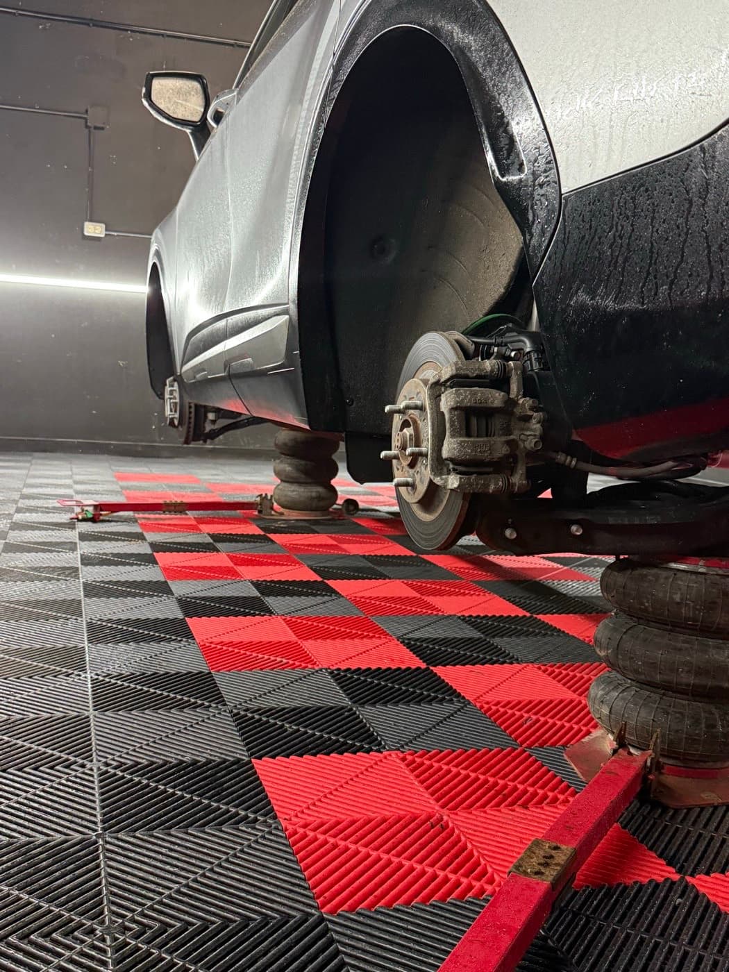 SUV raised on jacks with a wheel off and the brake rotor exposed at PitStop & Go