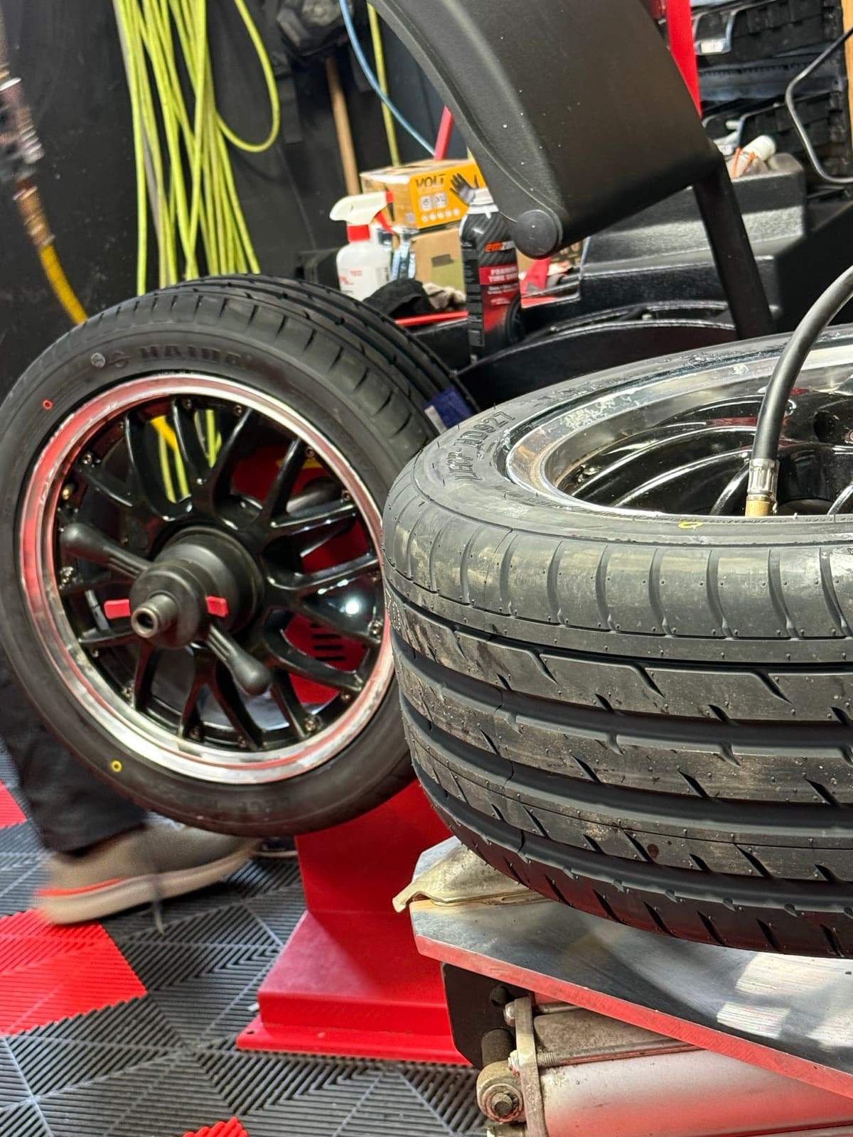Black multi-spoke rim on the tire-mounting machine at PitStop & Go in Fredericton