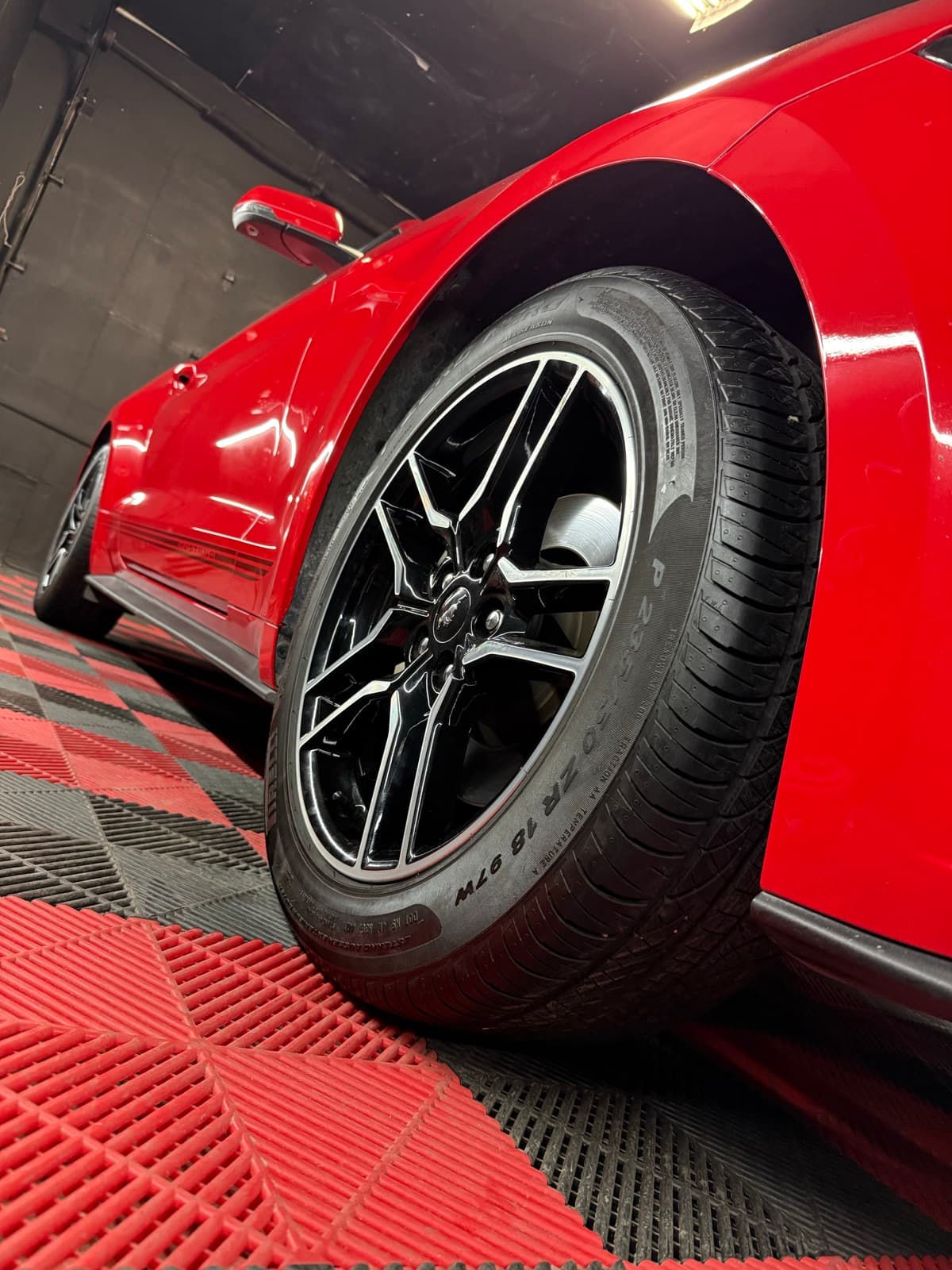 Freshly installed wheel on a red sports car, ready to roll out