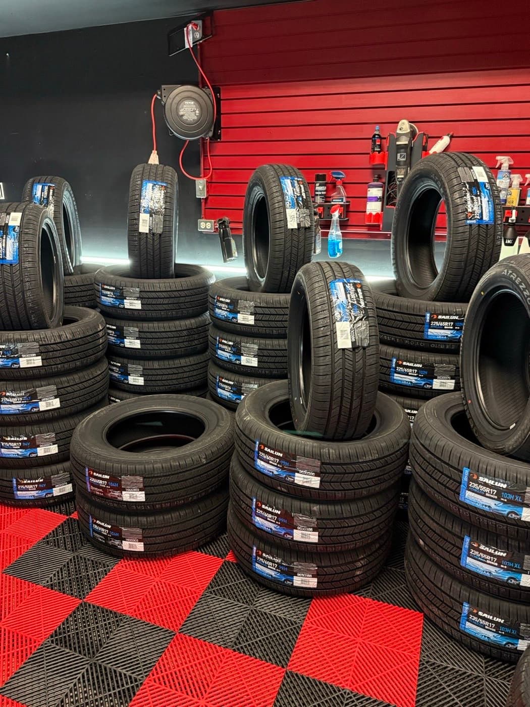 Stacks of new tires with manufacturer labels on the shelf at PitStop & Go in Fredericton