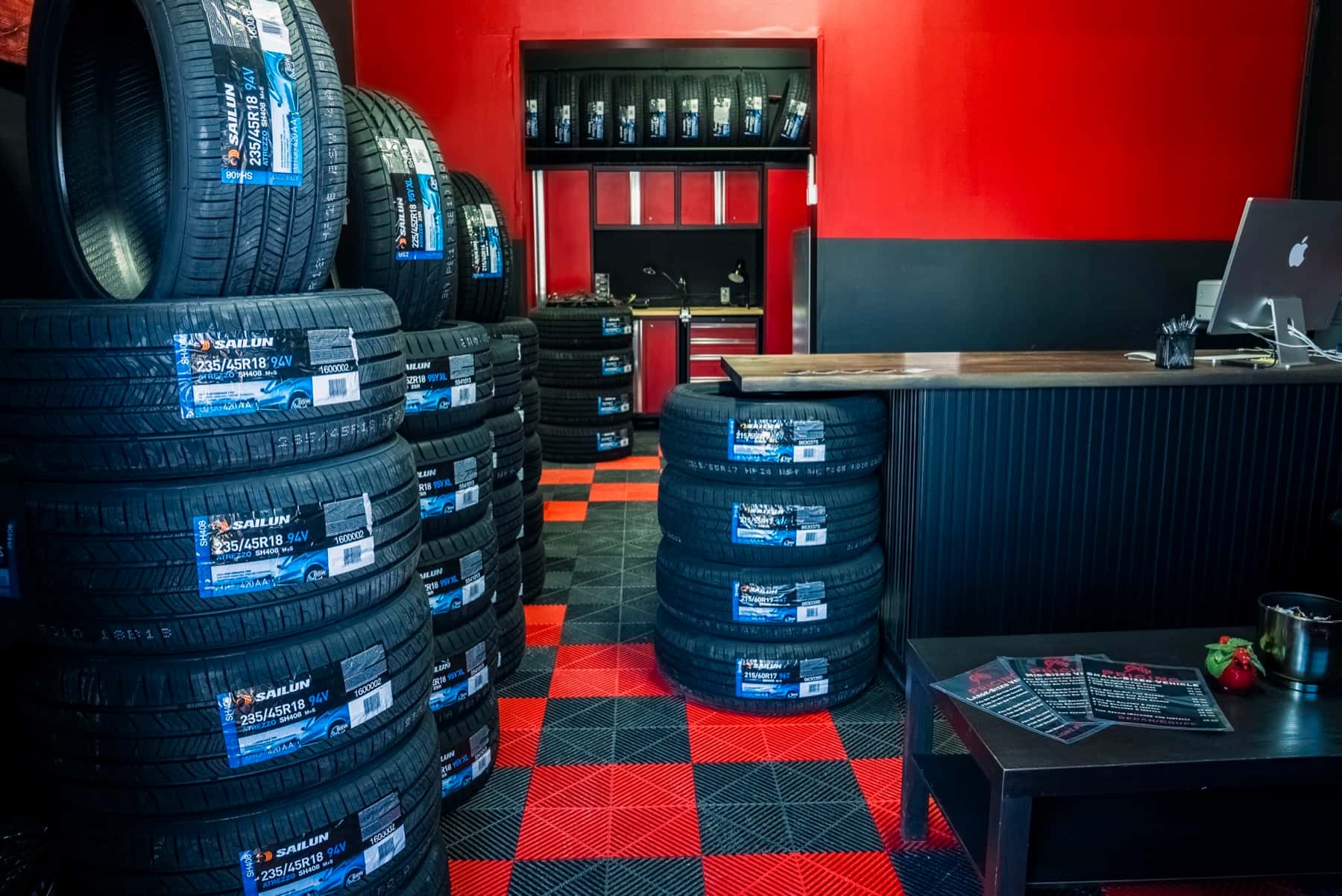 Sailun tire showroom inside PitStop & Go, stacks of tires on red and black checker floor